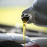 Fresh oil pouring into a car engine during a service