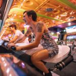 Couple playing an arcade racing game sitting on bikes